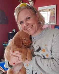 Strong Female Head of a Youth Ranch Staff Holding Puppy